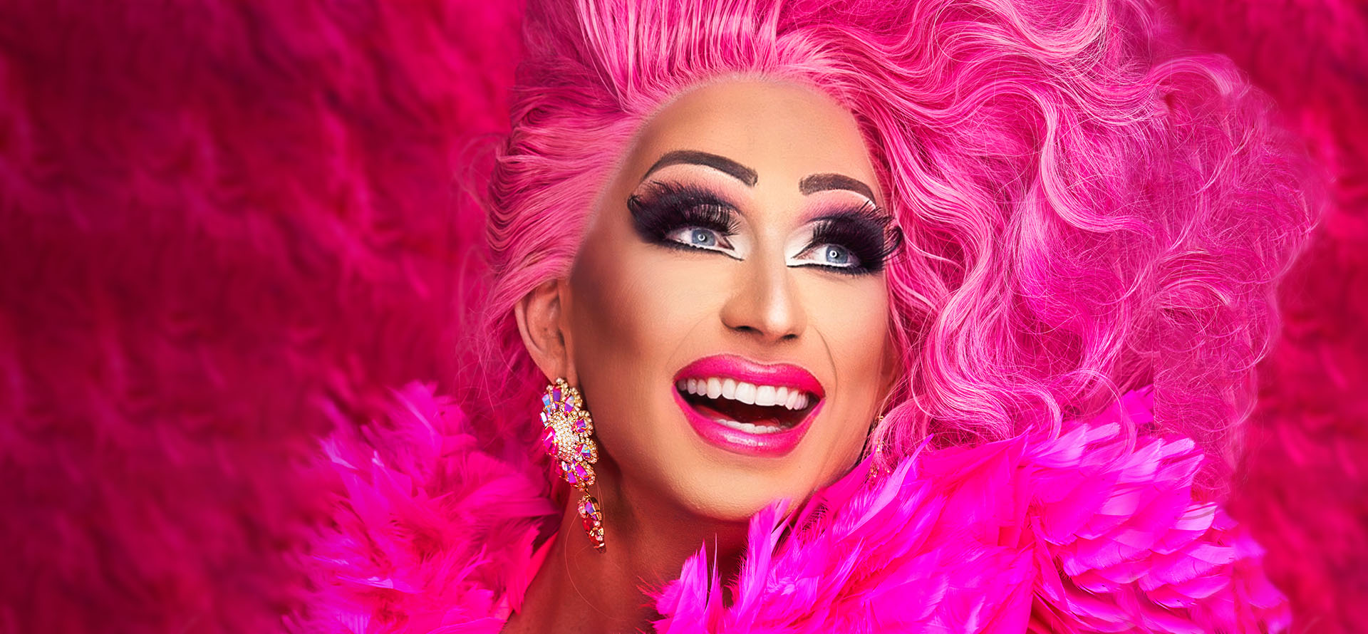 Drag-artisti suuressa pinkissä hiuspehkossa