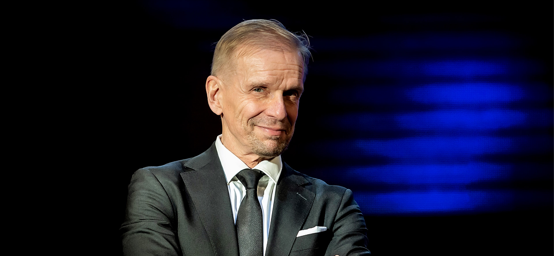 Jukka Puotila hymyilee maireasti puvussa