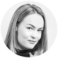 Nainen hymyilee kameralle mustavalkopotretissa